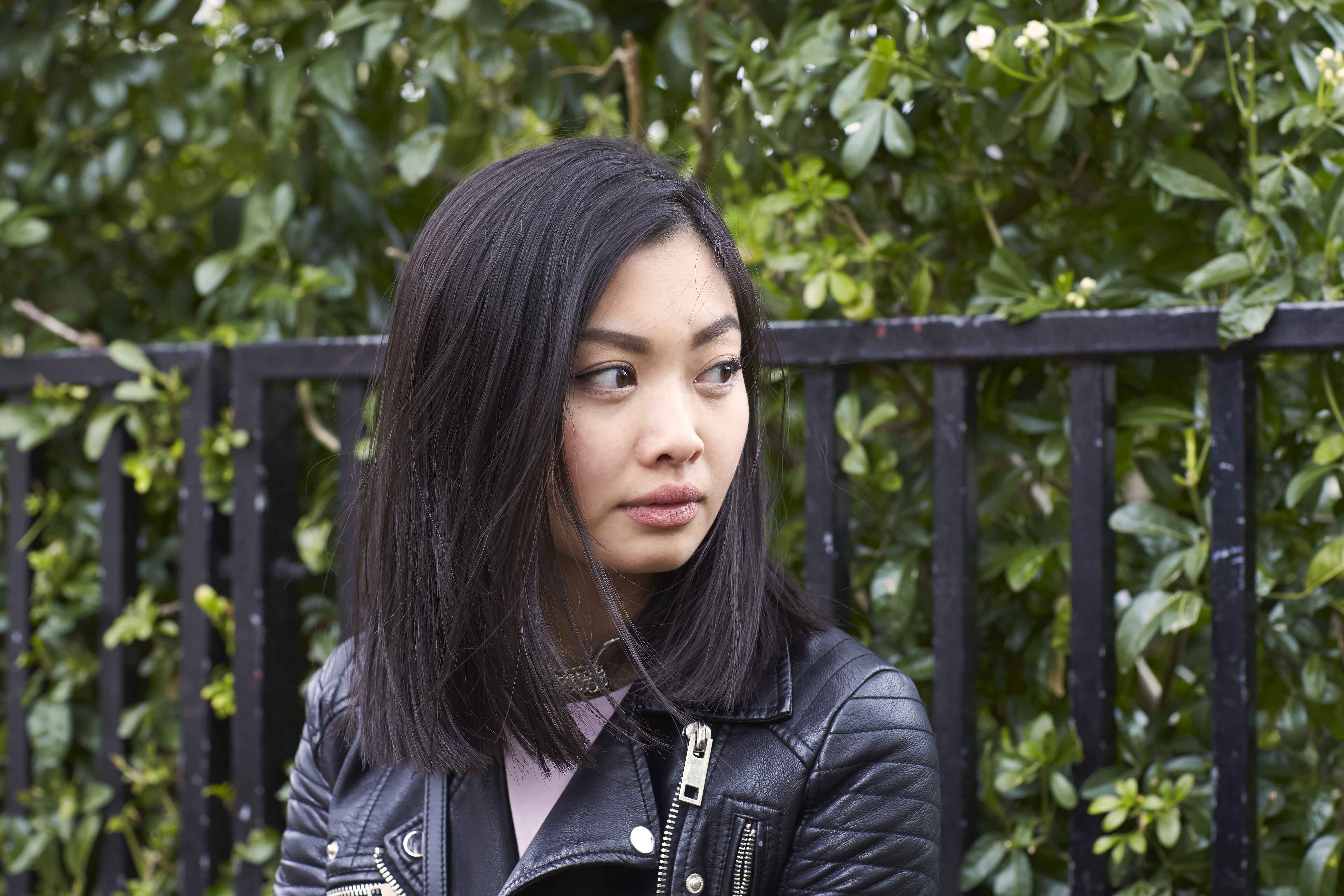 Medium length hairstyles for fine hair: Woman with dark brown straight bob wearing a leather jacket.