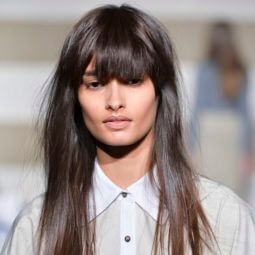 woman on the runway with long dark brown hair worn straight and with a full fringe cut in