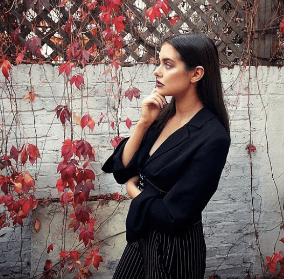 side view of a woman with dark slick back hair