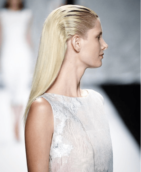 side view of a model with long blonde hair slicked back