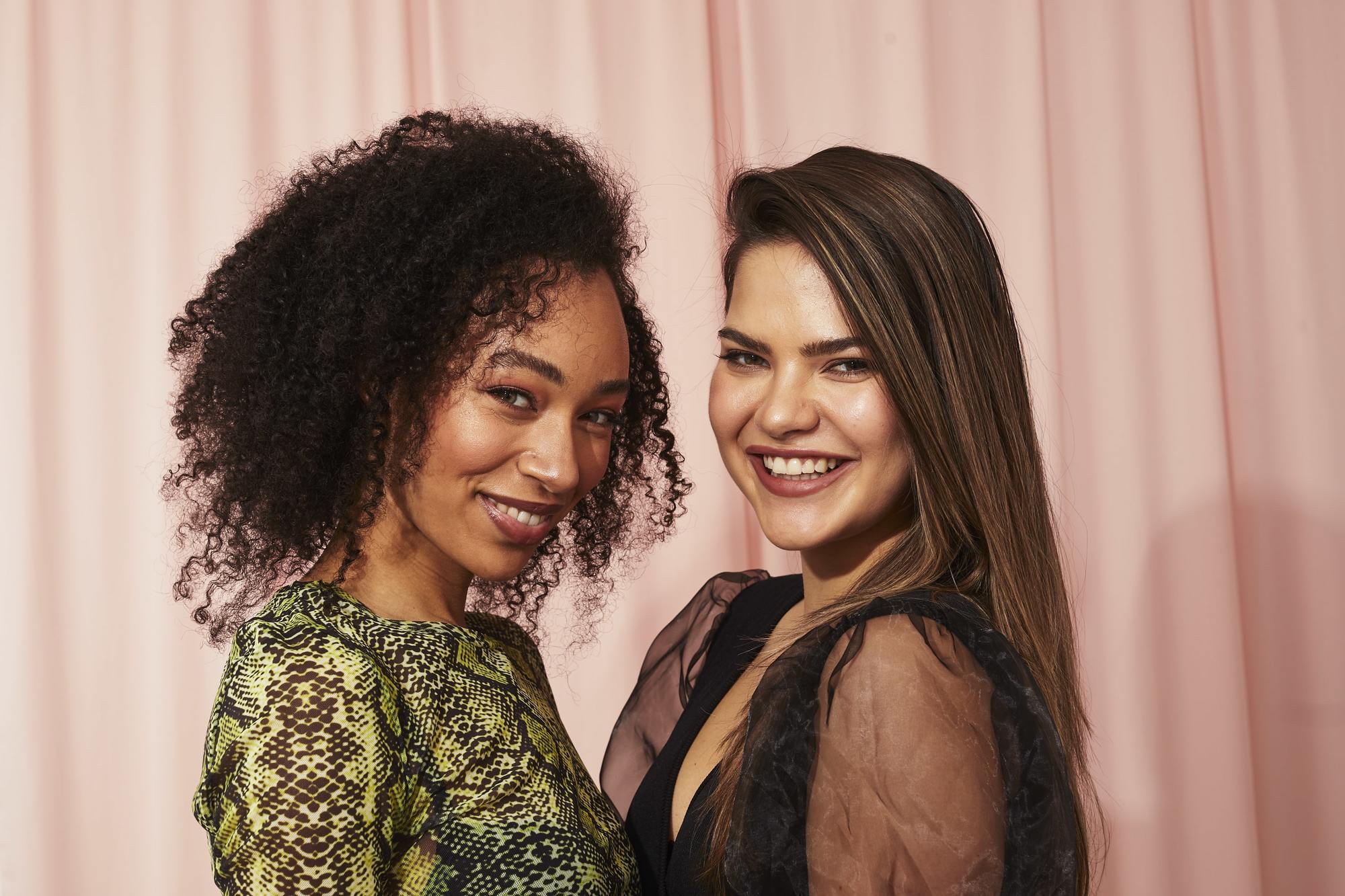 Two women, one with curly hair, one with long brown hair