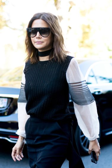 woman on the street wearing large sunglasses with her medium brunette hair cut into a wavy bob