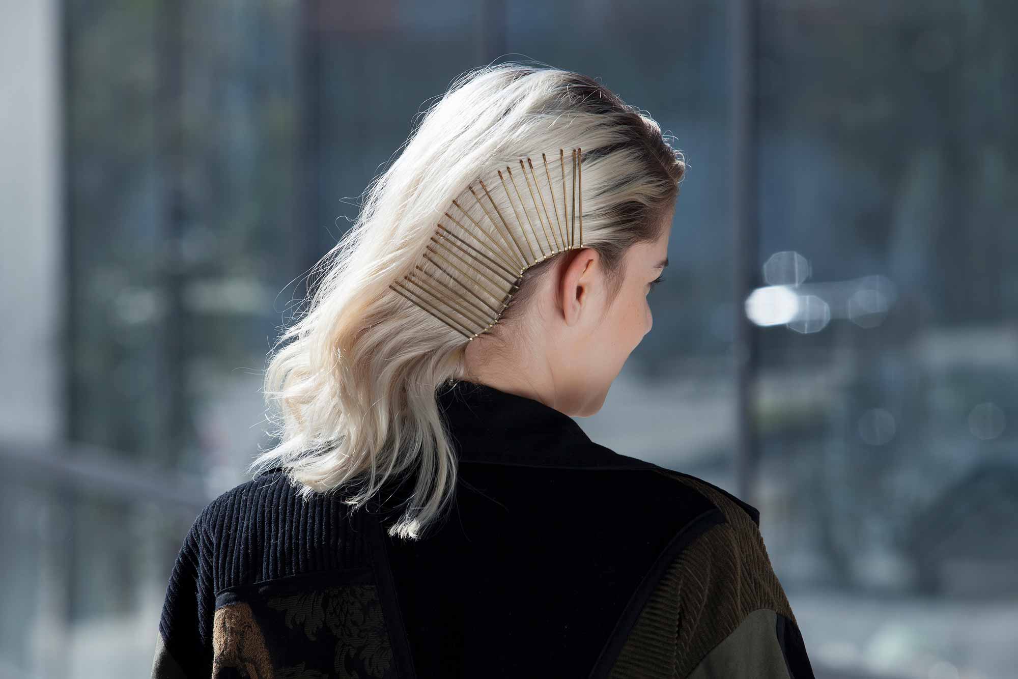 Bobby pin hairstyles: Closeup shot of a woman with side-swept bleach blonde hair styled with bobby pins