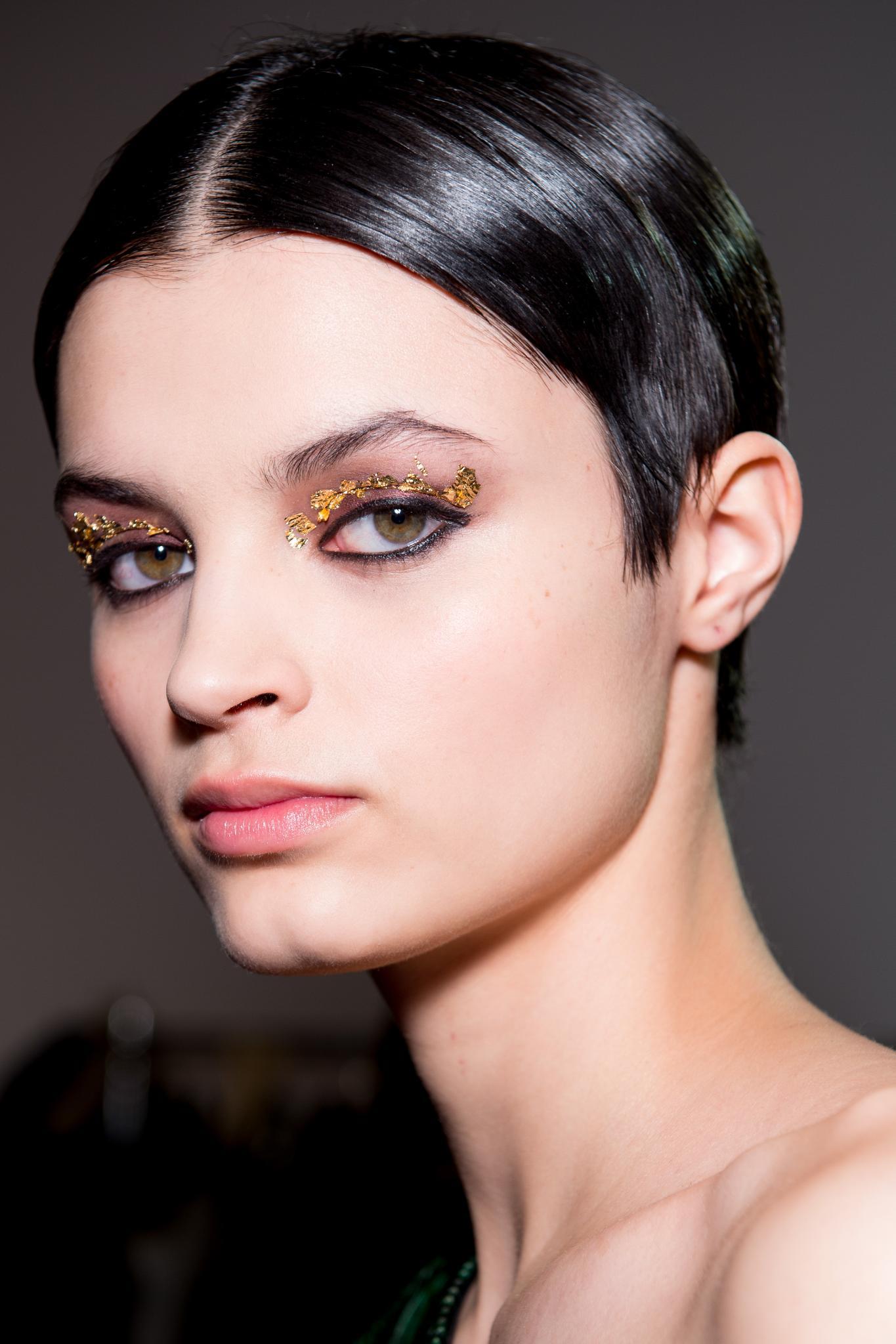 Very short hairstyles: Brunette model with slicked back short pixie hairstyle and middle parting