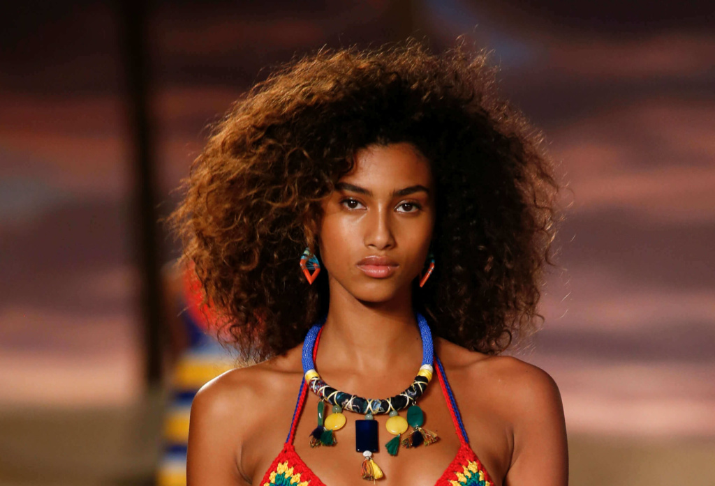 model with a big curly afro on the runway wearing tribal style clothing and jewellery