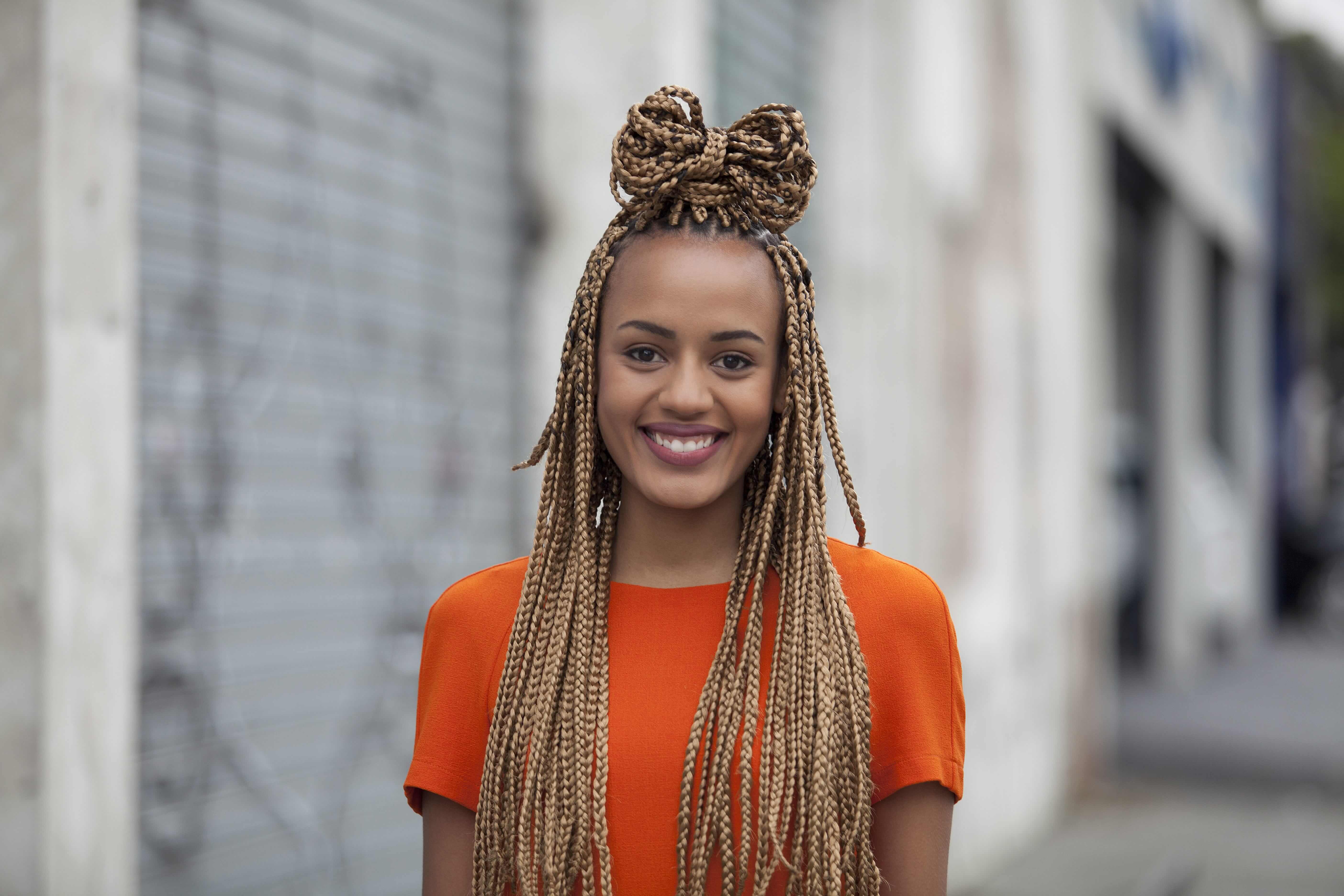 Young black girl with blonde box braids tied into a hair bow