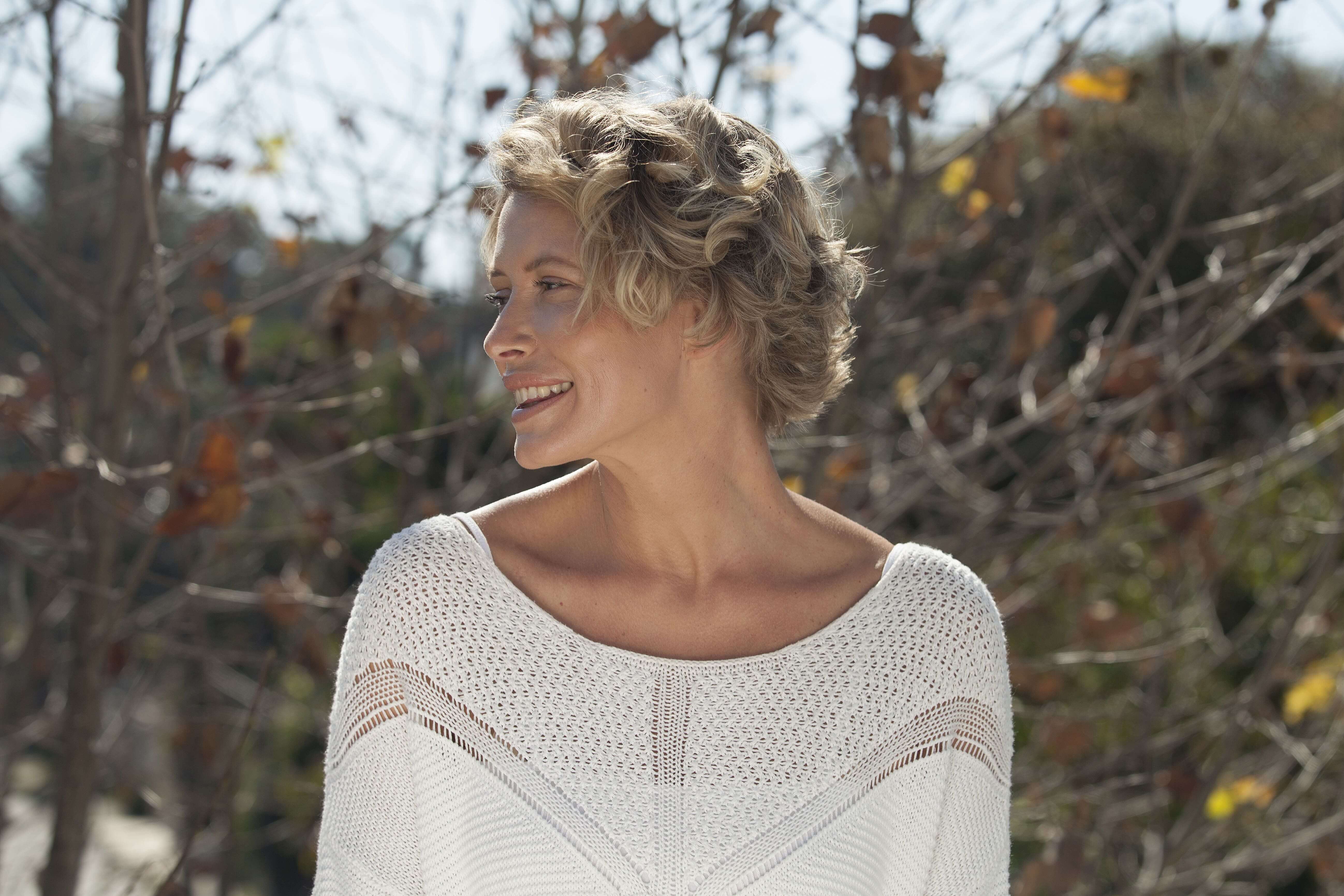 Short hairstyles for fine hair: Blonde woman with short wavy pixie cut.