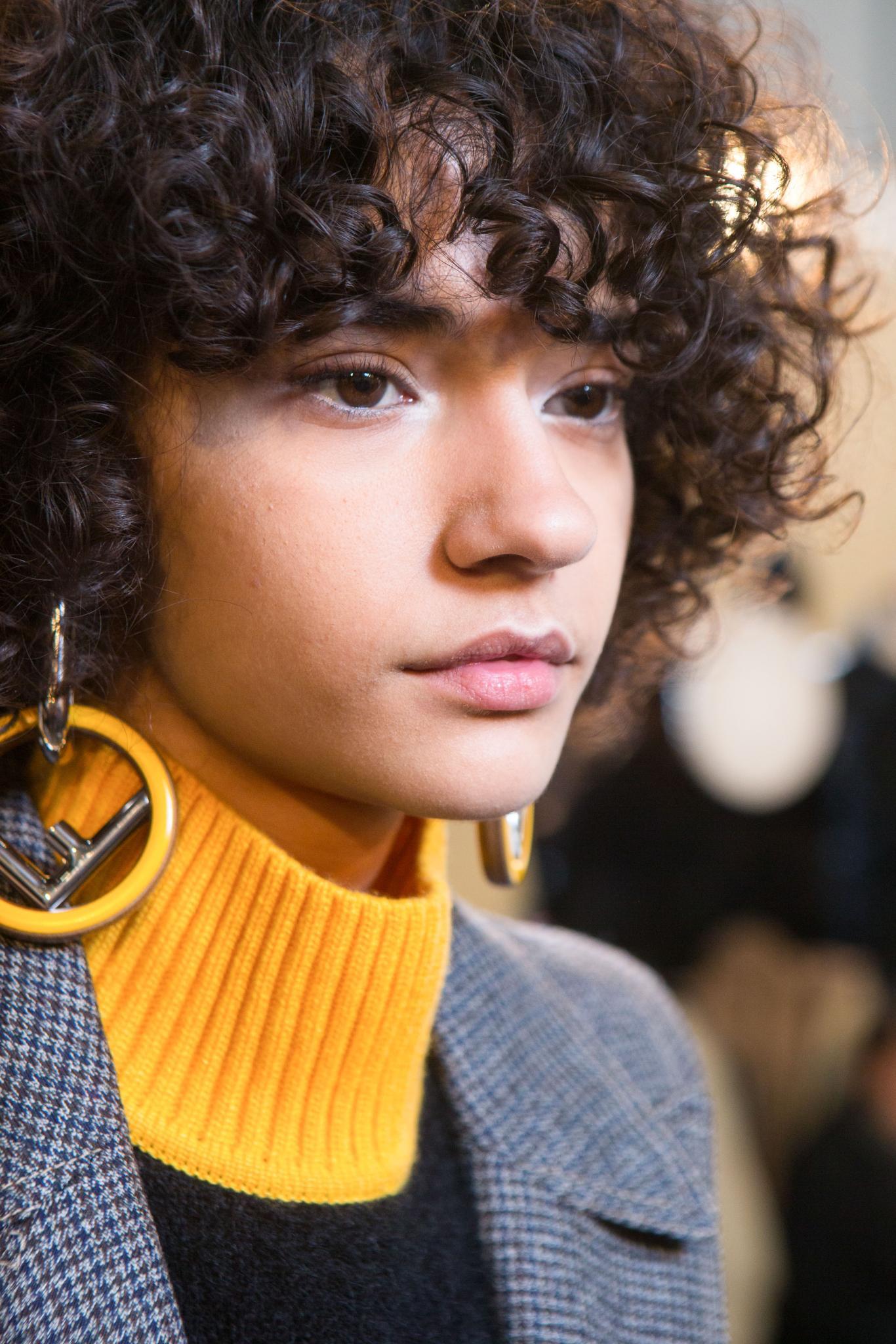 Very short hairstyles: Brunette model with short curly hair in a modern shag