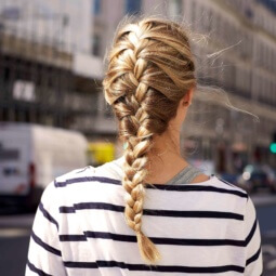 back view of a woman's hair with a golden-blonde-french-braid