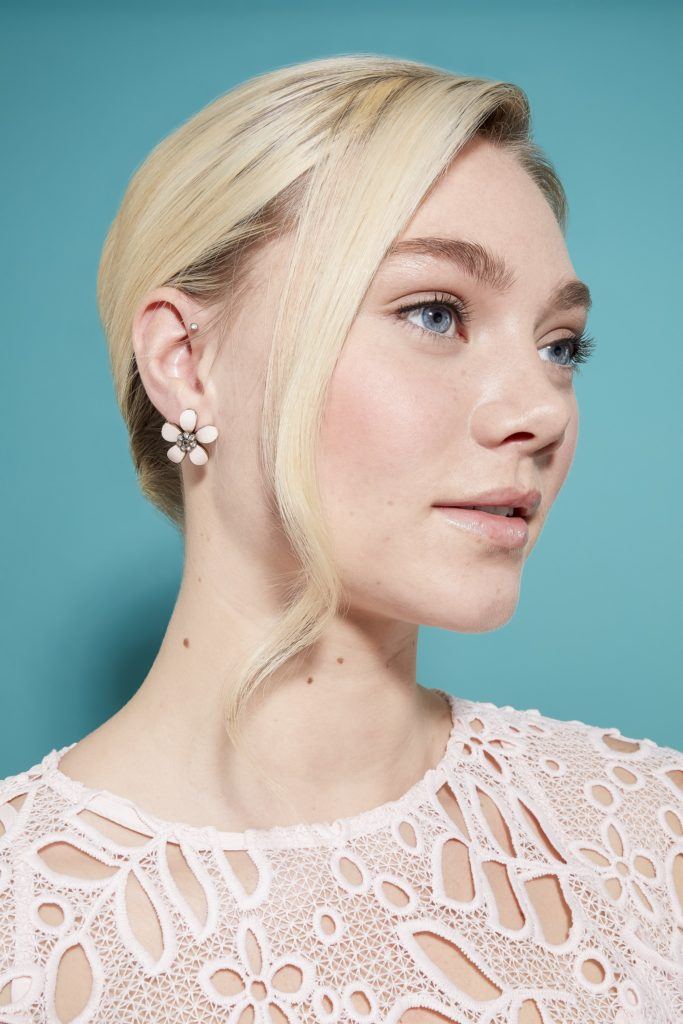 model with light blonde hair rolled into a french twist updo, with loose hair at the front of her look to frame here face