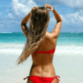 Blonde girl raking hair hands through her hair on the beach