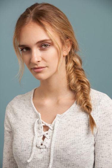 Inverted fishtail braid tutorial: A young blonde woman with an inverted fishtail braid