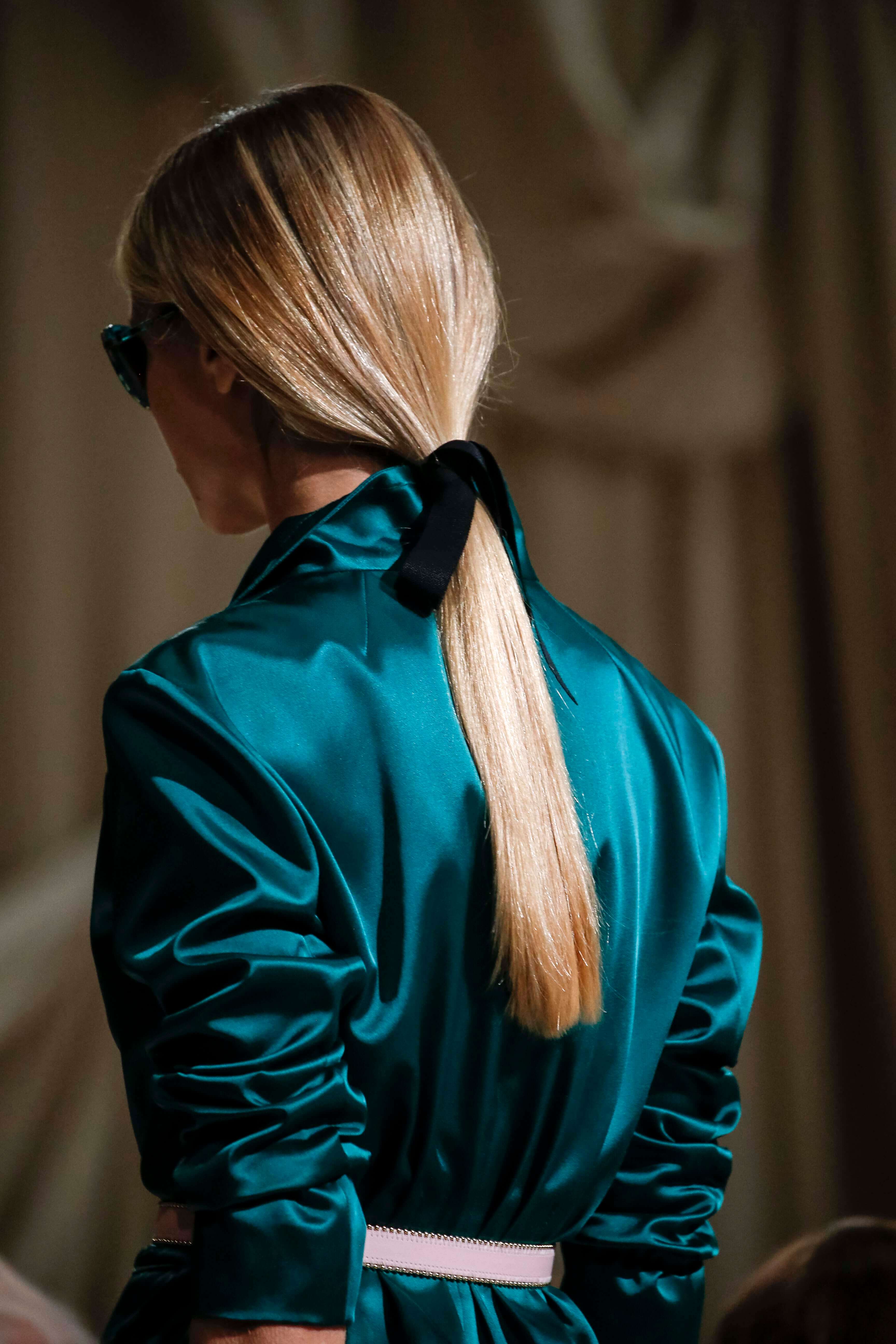 model with blonde hair wearing a low ponytail hairstyles for straight hair