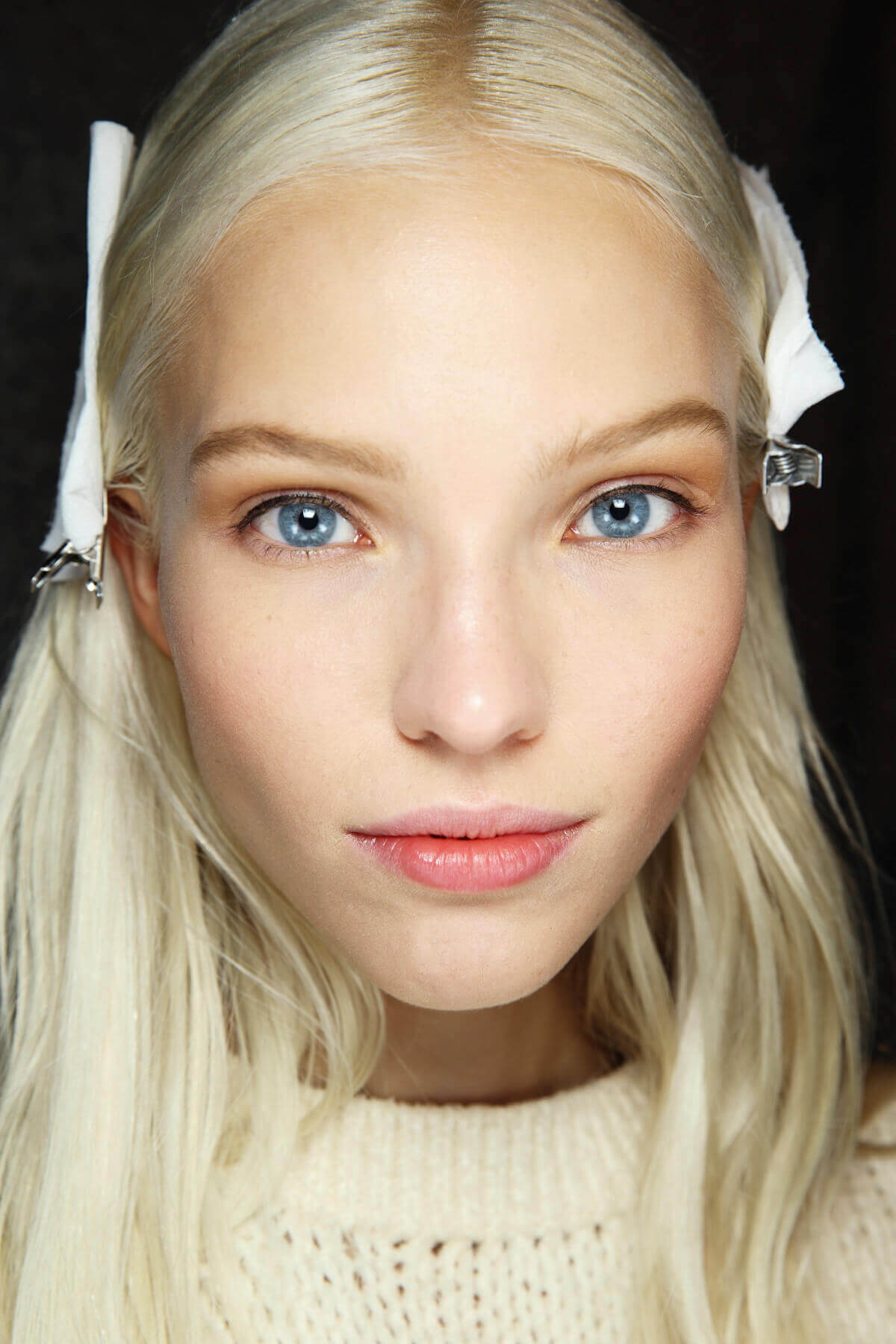 Hair straightening treatment: Model with platinum blonde straight hair secured using silver clips backstage at Roberto Cavalli SS14 show.