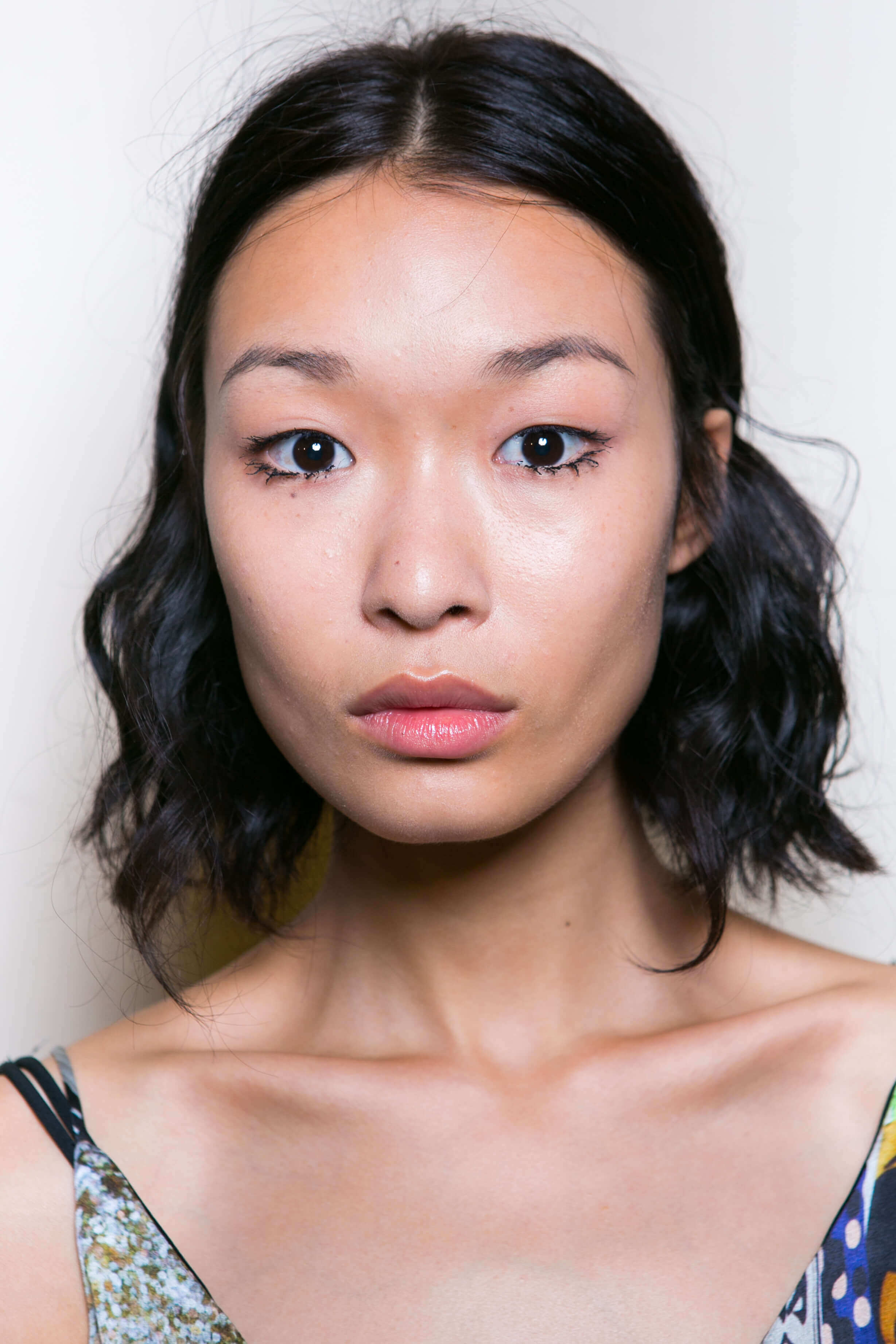 Short hairstyles or fine hair: Asian model backstage SS16 with dark brown wavy long bob and minimal makeup.