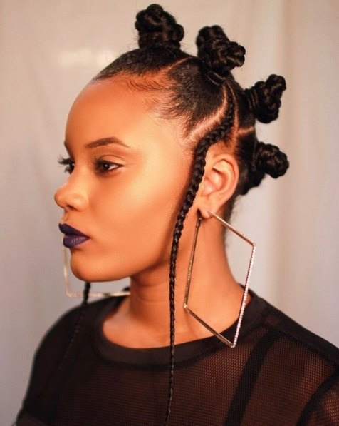 side profile of a lady with natural hair in bantu knots wearing oversized diamond shaped earrings