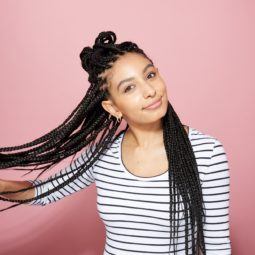 How to style box braids: Side view of ATH editor Amra with a half-up bun with box braids