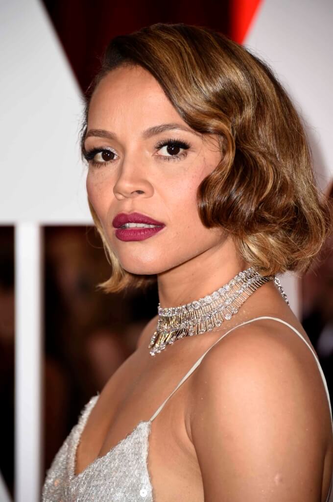 carmen ejogo with a wavy golden brown bob with a silver dress and necklace on the red carpet