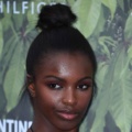 Leomie Anderson at the serpentine summer party with her dark brown natural hair tied into a topknot