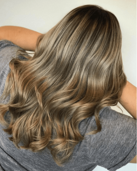 back view of a woman's hair with long waves and different shades of blonde colour