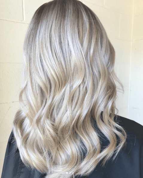 back view of a woman's long blonde hair with pearl blonde tones