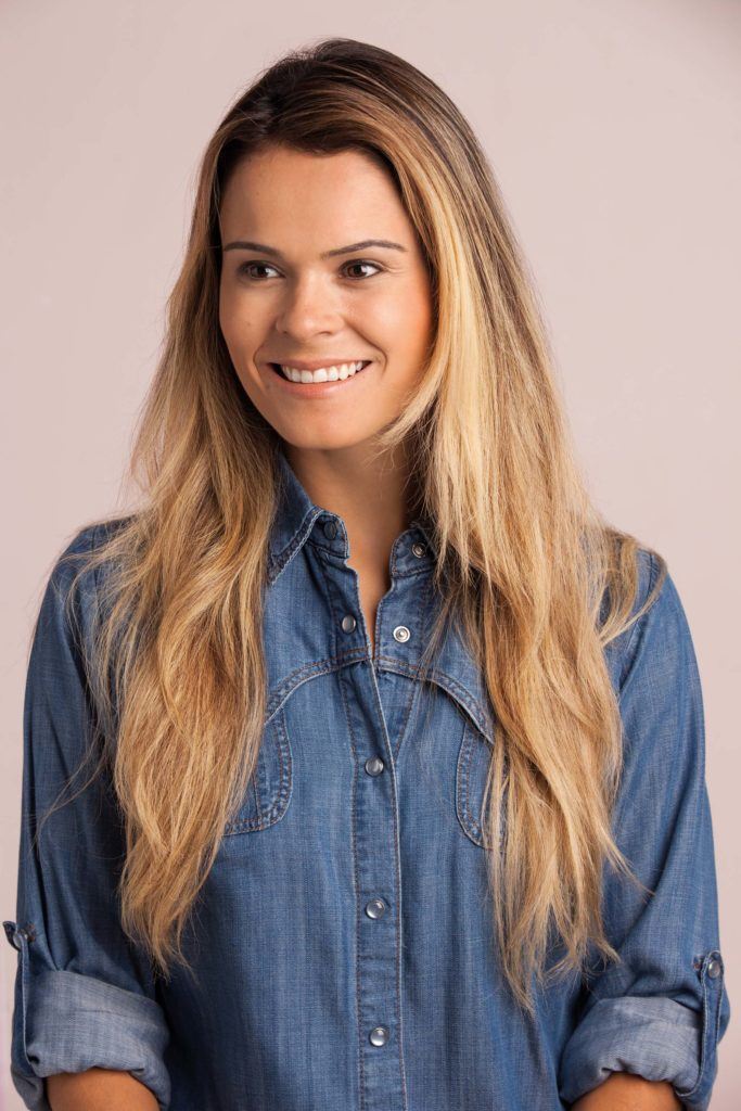 braid top knot: blonde woman with wavy hair wearing a denim shirt