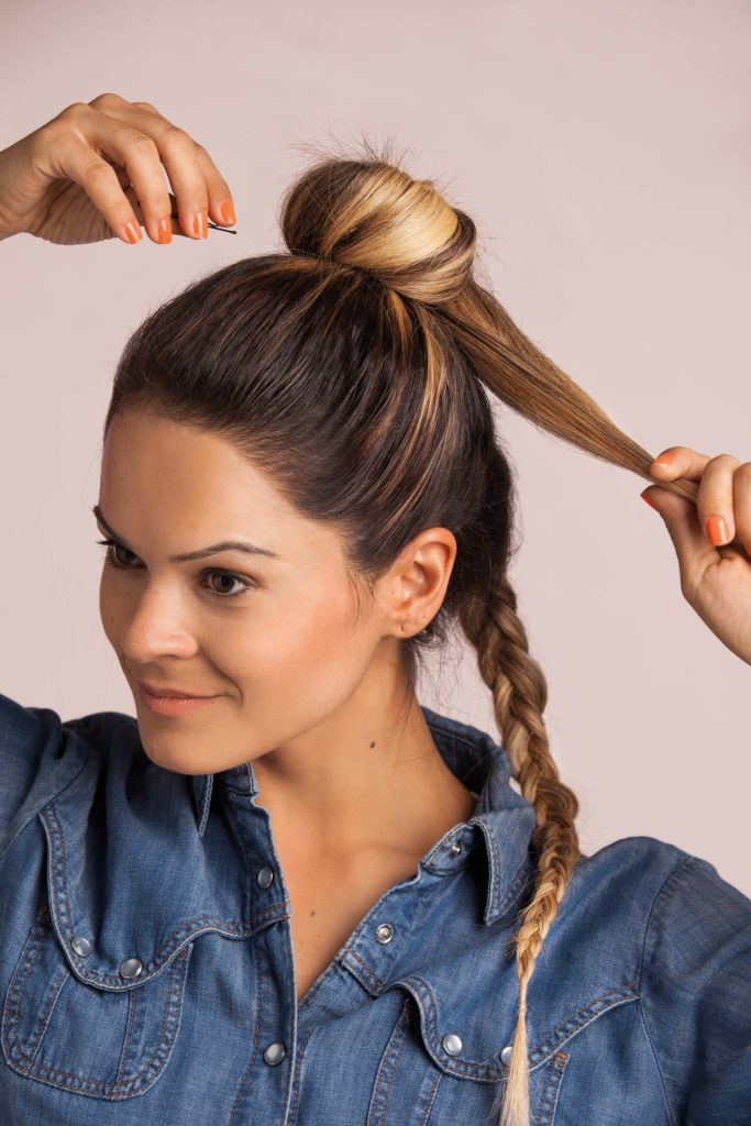 French braid into a top knot: blonde woman with a braid creating a bun