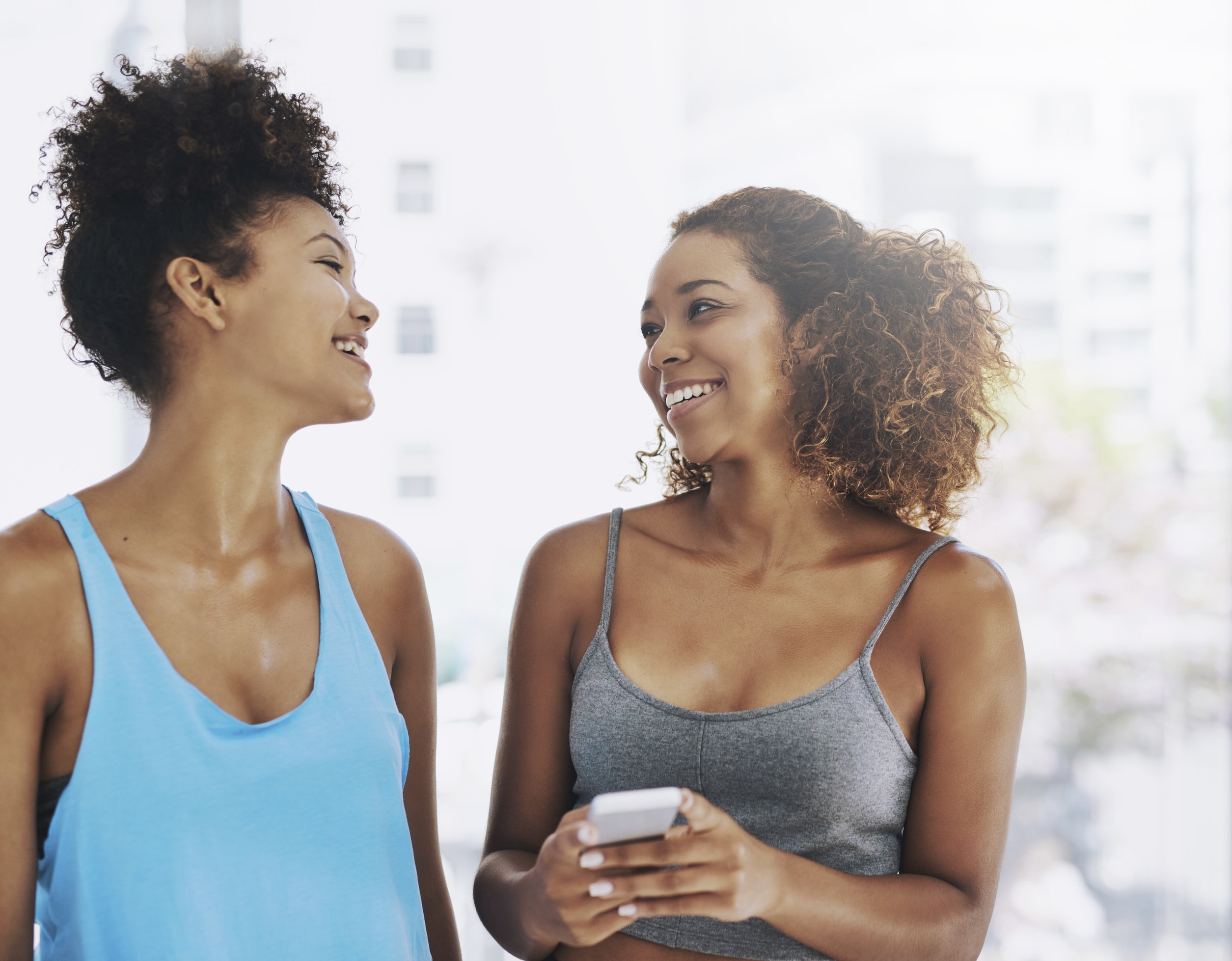 two black natural hair women laughing