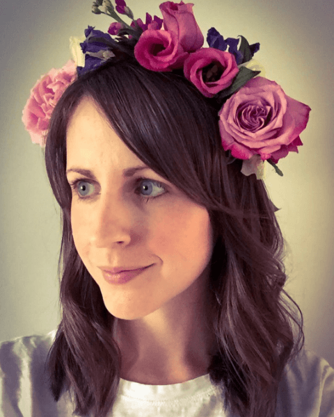 Festivals accessories: woman with a pink flower garland in medium length brown hair