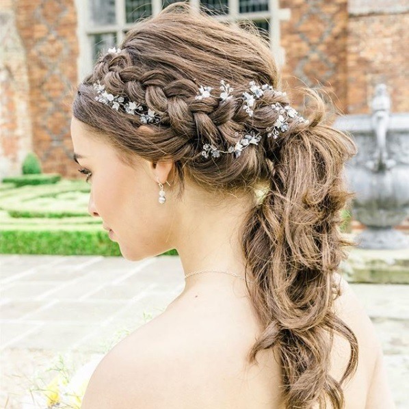 Wedding hairstyles for long hair: Brunette with curly long hair in a braided ponytail