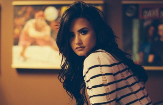 demi lovato long black hair sitting in a bedroom