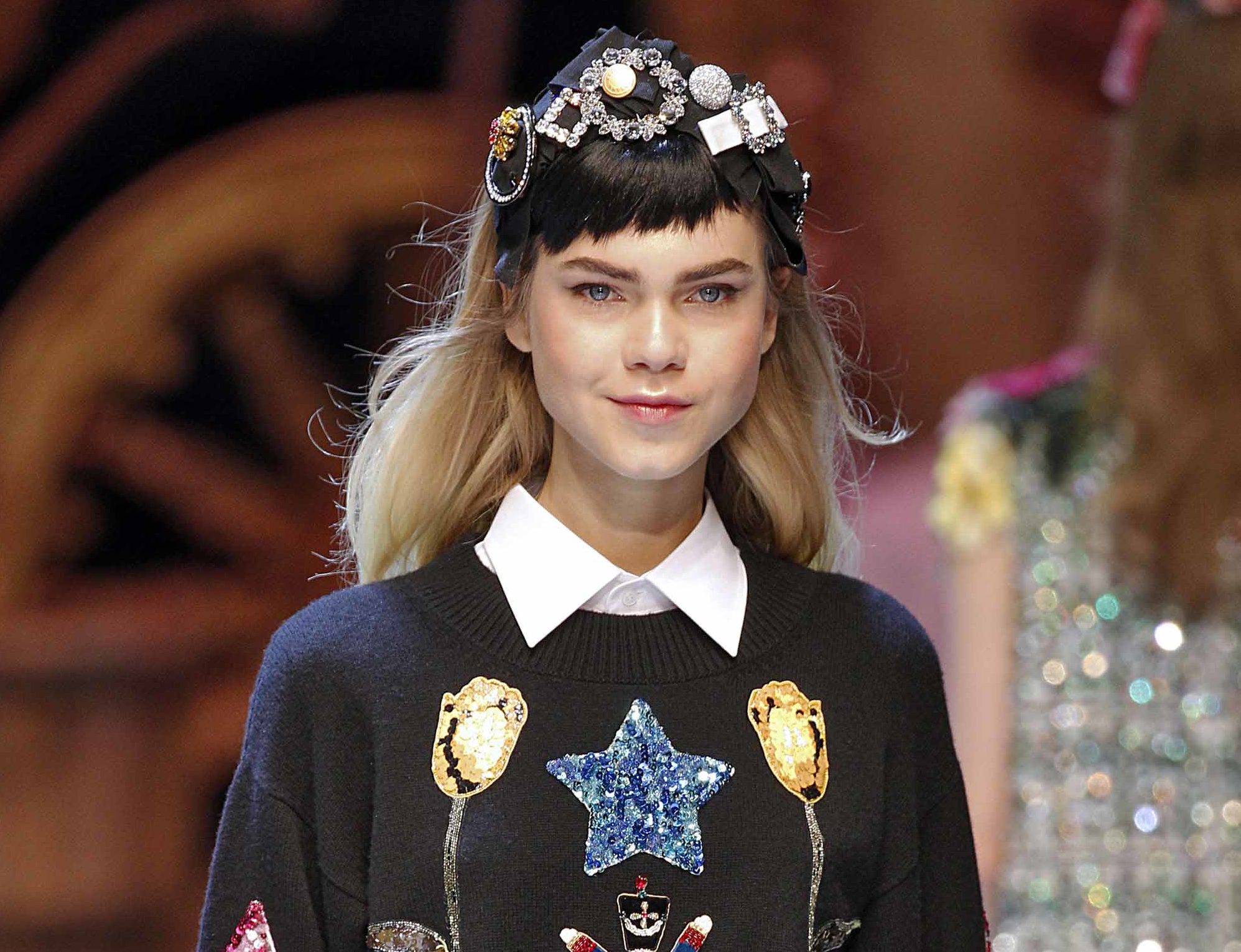 model with long blonde hair with brown micro fringe wearing jewelled headband and logo jumper and white shirt at aw16 fashion week