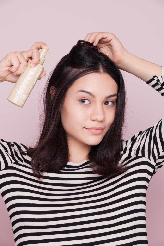spraying hair with a volumiser
