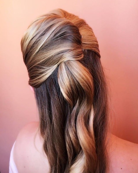 Wedding hairstyles for long hair: Back view of a woman with bronde hair in a curly half-up French twist