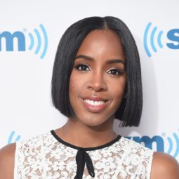close up shot of kelly rowland with sleek chin length bob hair, wearing white top and posing on the red carpet