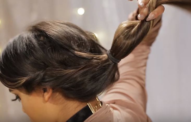 Gibson girl hair tutorial: Back view video still of YouTuber Nikki Secret with her hair in a ponytail