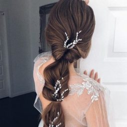 Wedding hairstyles for long hair: Back view of a brunette woman with waist-length hair in a bridal topsy turvy ponytail style