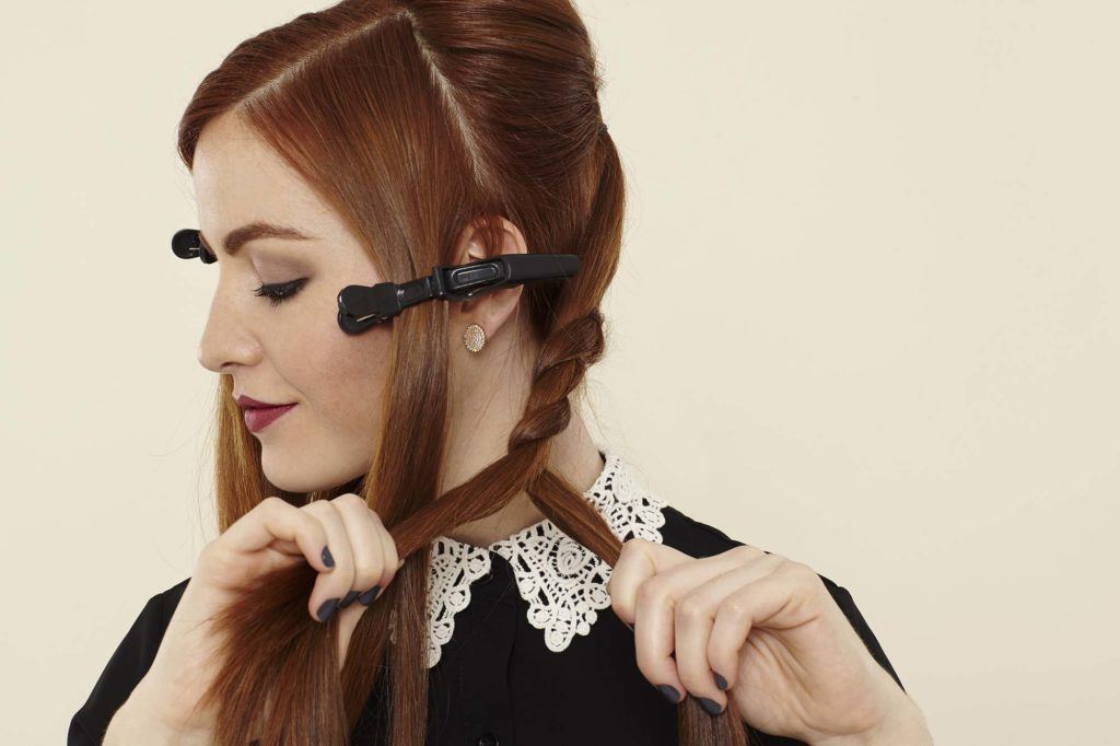 The side view of a redheaded model creating a rope braid
