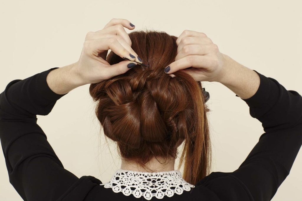 a twisted updo woman doing her hair