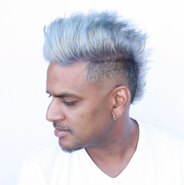 Asian man with silver mohawk hairstyle looking down