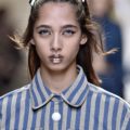 model on the Fendi SS17 runway with brunette hair worn in pigtails with candy look accessories attached and glitter lips wearing a striped outfit