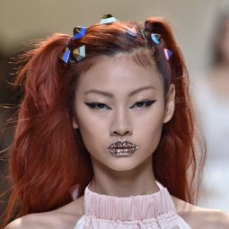 model on the Fendi SS17 runway with dyed red hair worn in pigtails with candy look accessories attached and glitter lips