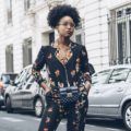 close up shot of woman afro styled into a pineapple hairstyle, wearing printed silk suit and posing on the street