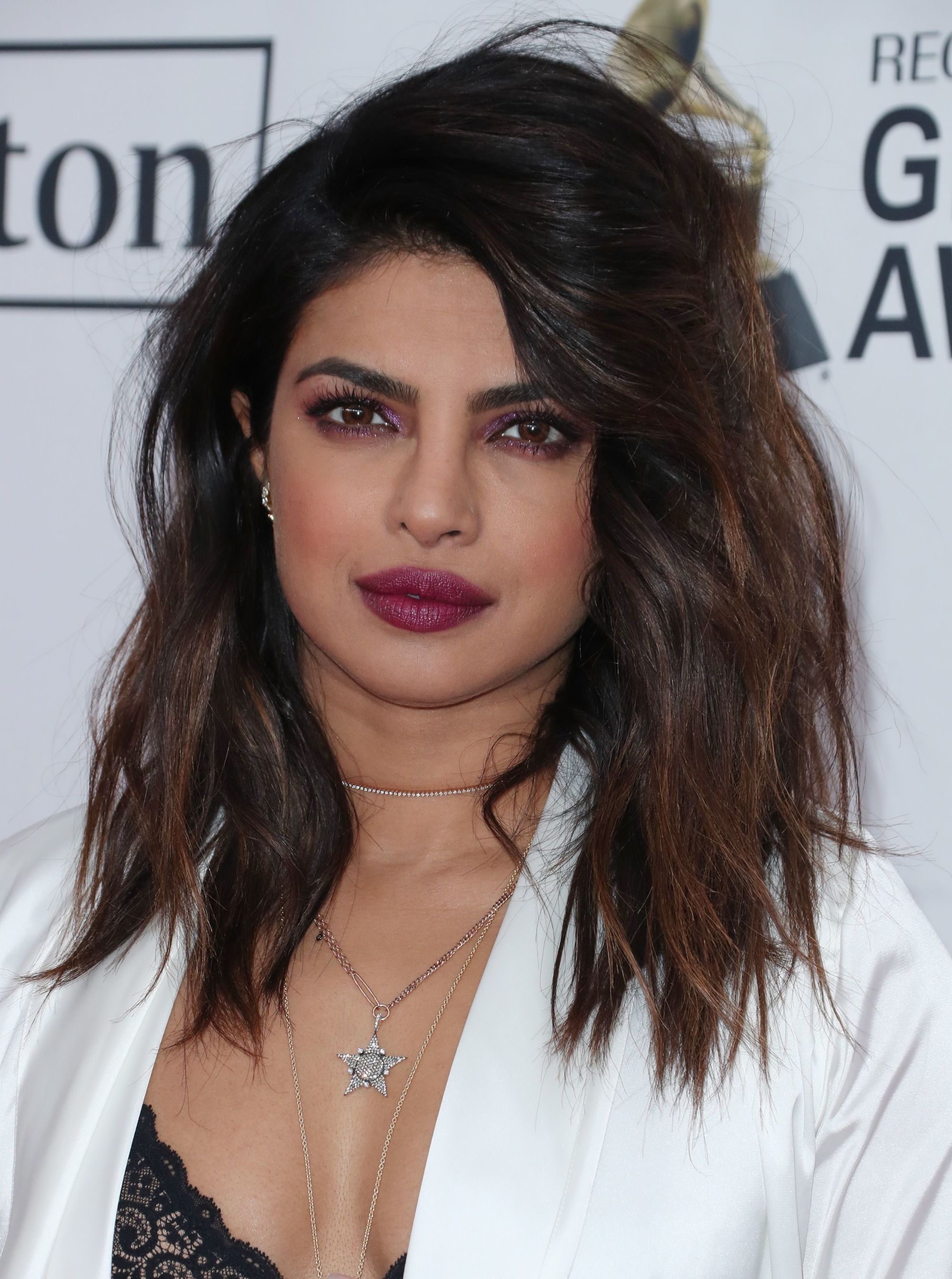Medium hairstyles for thick hair: Priyanka Chopra Jonas with mid-length layered dark brunette hair with caramel highlights