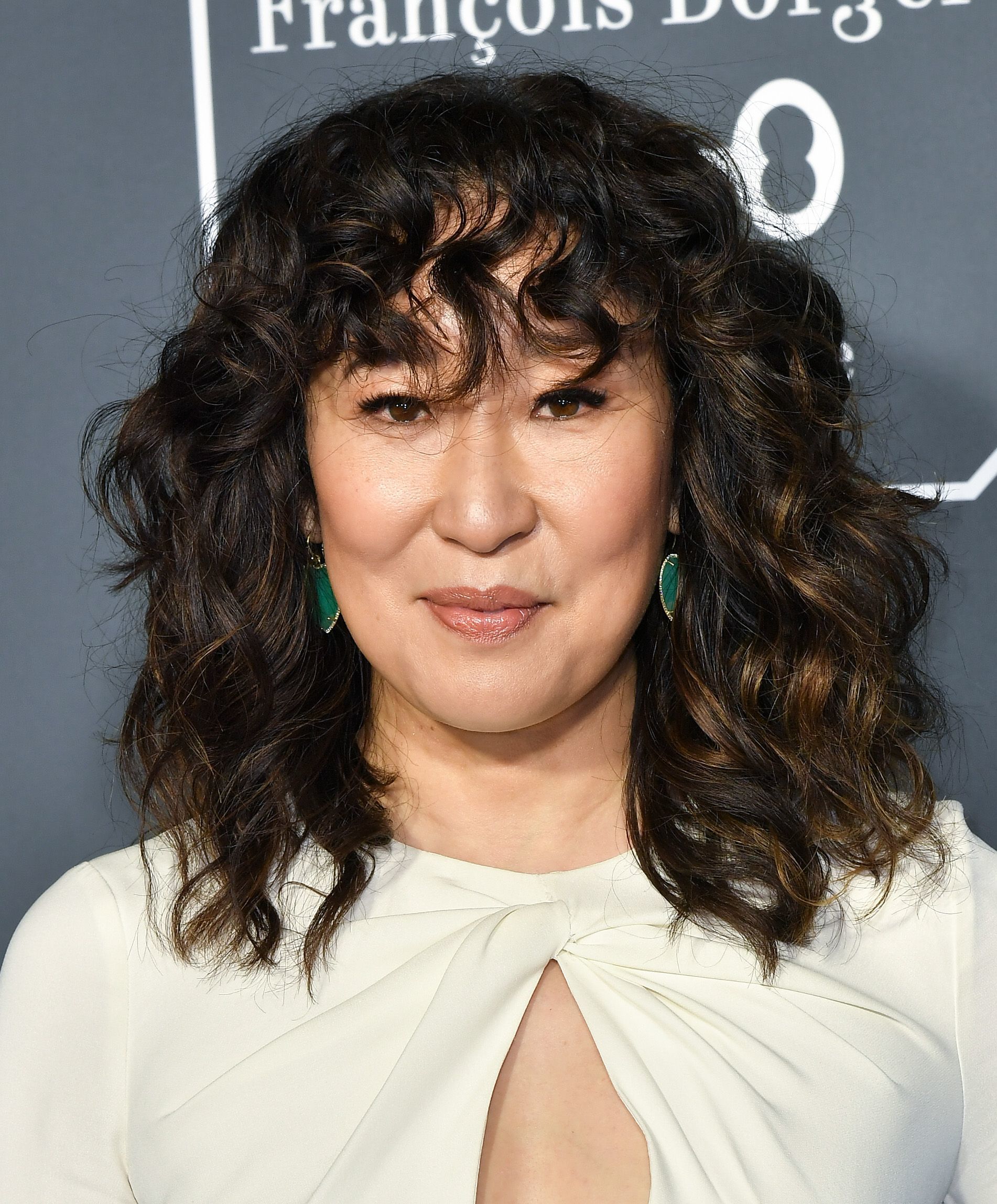 Medium hairstyles for thick hair: Sandra Oh with a dark brown curly shag