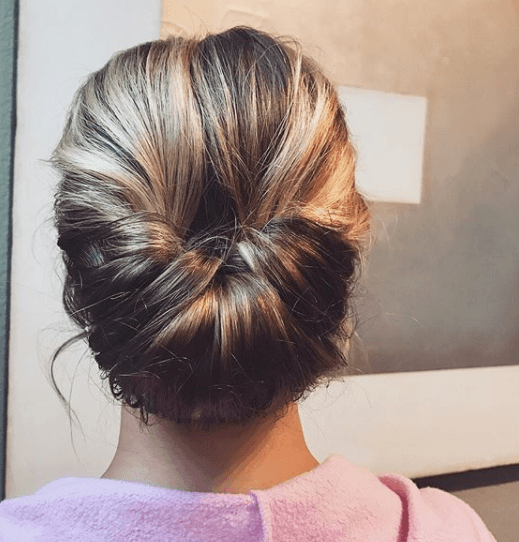 Gibson girl hair: Back view of a woman with honey blonde hair in a gibson tuck hairstyle