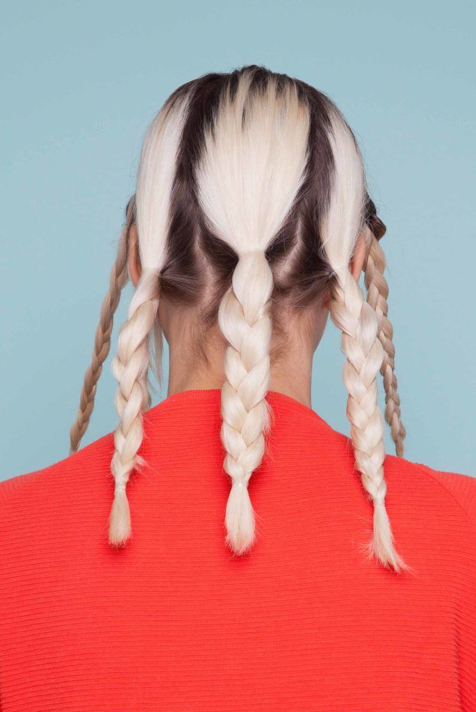 Snake braid hairstyles: back view of blonde woman with multiple braids mid way through snake braid tutorial