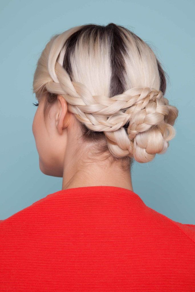 Snake braid hairstyles: Back view of blonde woman with hair styled in a snake braid bun updo.