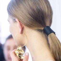 back view of a model with brunette hair worn in a low ponytail and a belted accessory at the Tibi SS17 show wearing a pair of large hooped earrings
