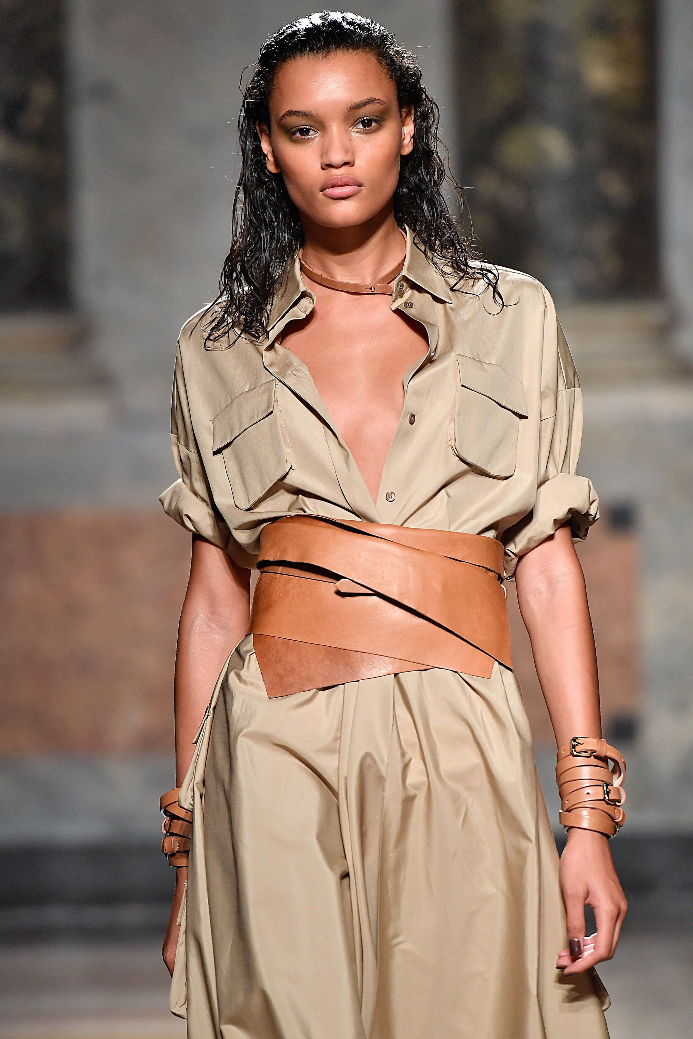 close up shot of model with wet look curls, wearing nude dress and leather belth on the LesCopains runway